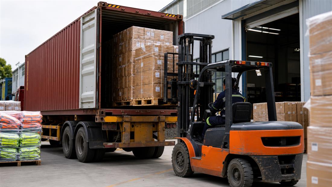Forklift loading packed cartons into a shipping container